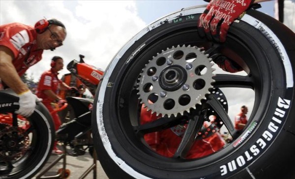 Due tecnici Bridgestone durante la sostituzione del pneumatico posteriore di una MotoGP