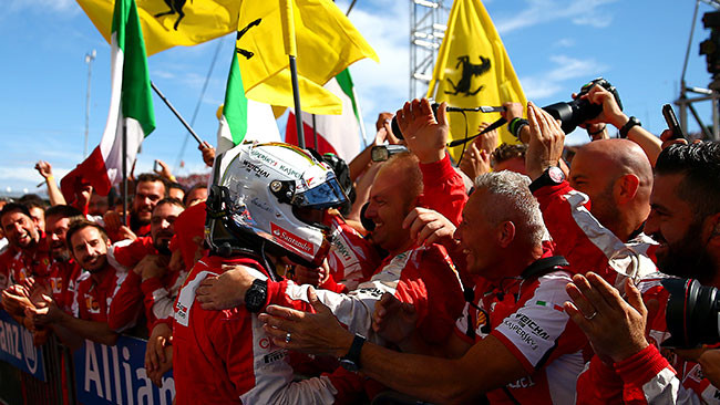 Sebastian Vettel festeggia la vittoria con i suoi meccanici